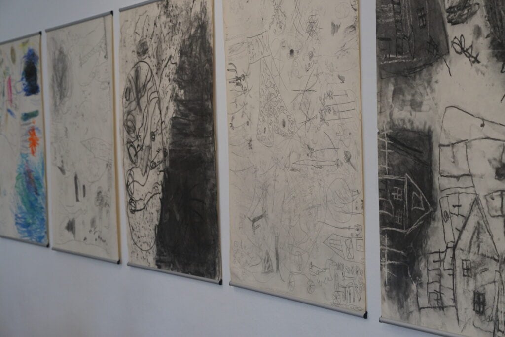 es werden fünf Bilder der Sonderausstellung überfahrt angezeigt. bis auf eines sind alle schwarz weiß. Motive sind gezeichnete Häuser, Fantasiefiguren und Landschaften.